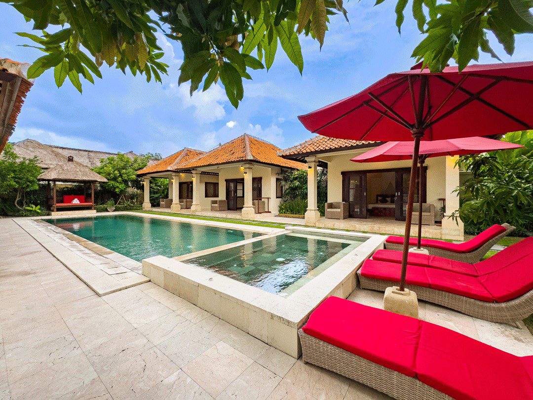 Sunny daytime perspective of the manicured lawn and private pool deck at Villa Santi Seminyak by Villa Bugis Seminyak villas.