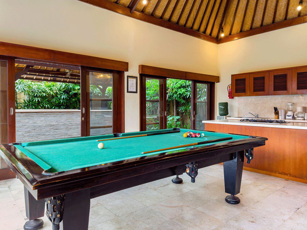 Pool table and cozy seating arrangement in the living pavilion at Villa Santi Seminyak by Villa Bugis, a standout feature among Seminyak villas.