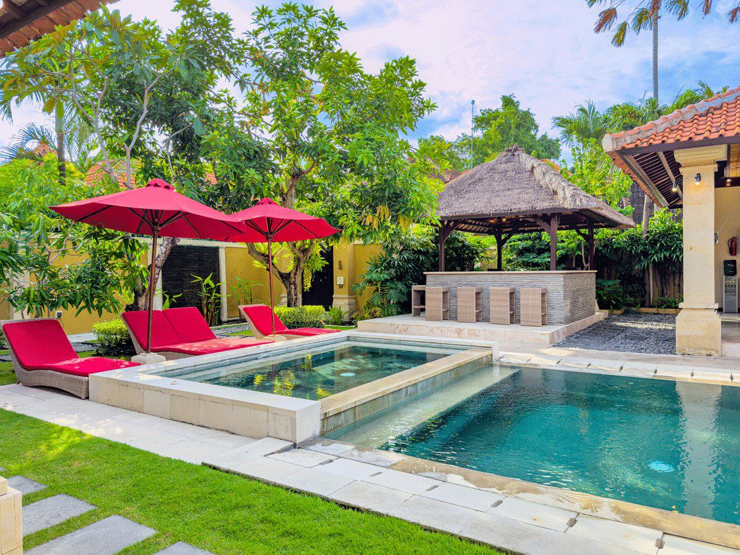 Tropical garden terrace and sunbathing area enclosing the swimming pool at Villa Santi Seminyak by Villa Bugis villa Seminyak.