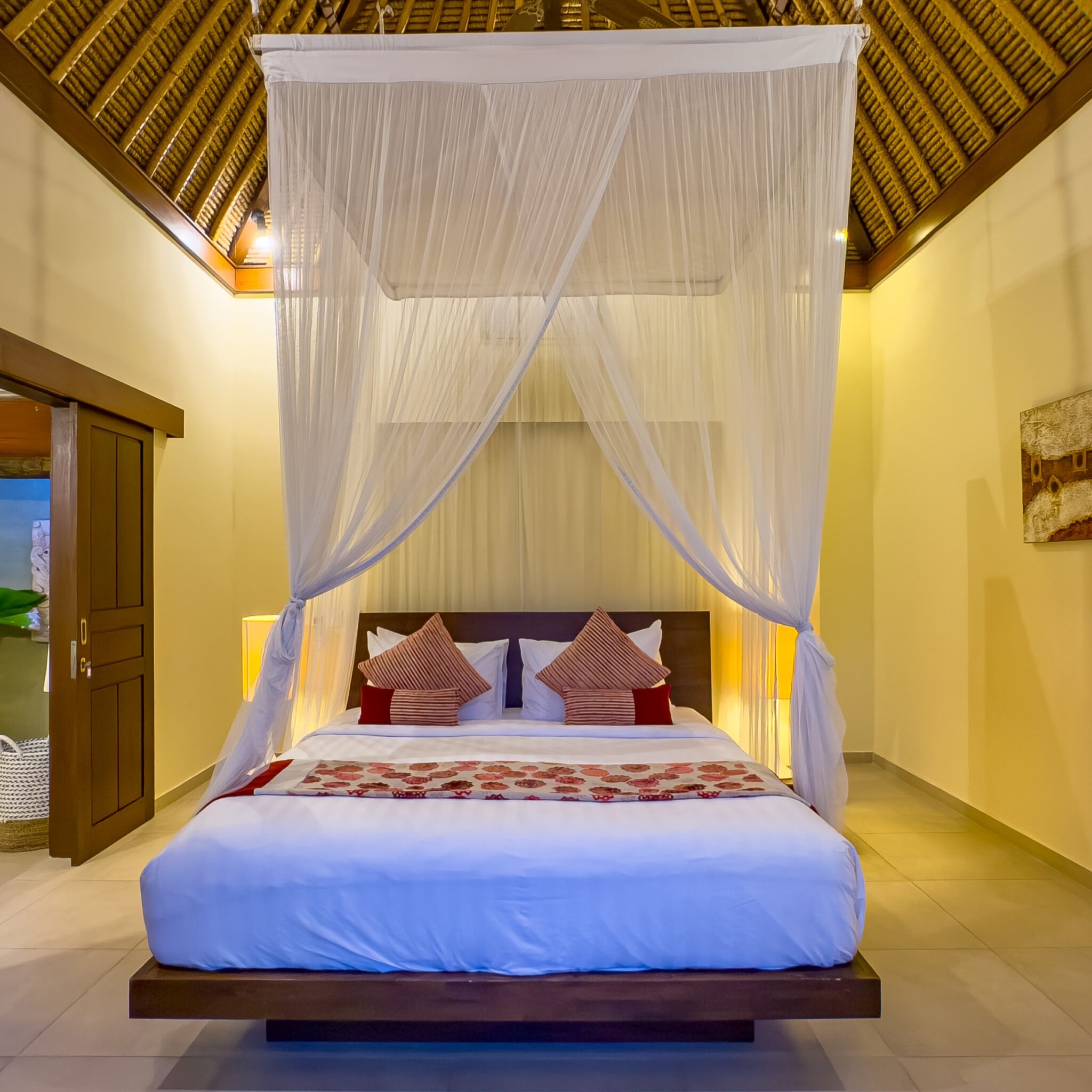 Spacious interior layout of bedroom 1 at Villa Saphir Seminyak by Villa Bugis Seminyak villas, complete with air conditioning and elegant wooden furnishings.