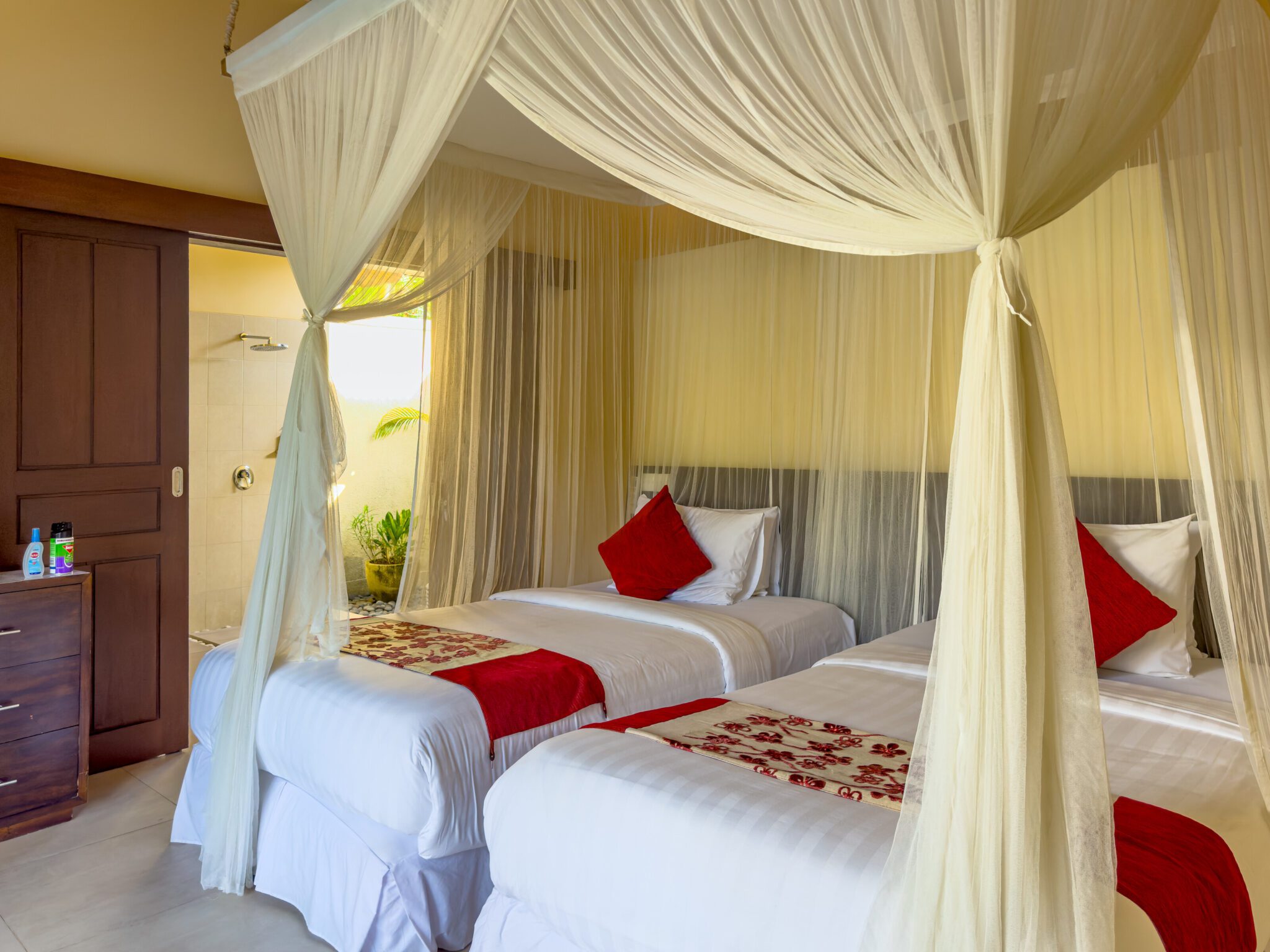 Airy twin bedroom interior setup at Villa Saphir Seminyak by Villa Bugis Seminyak villas, equipped with air conditioning and comfortable double single beds.