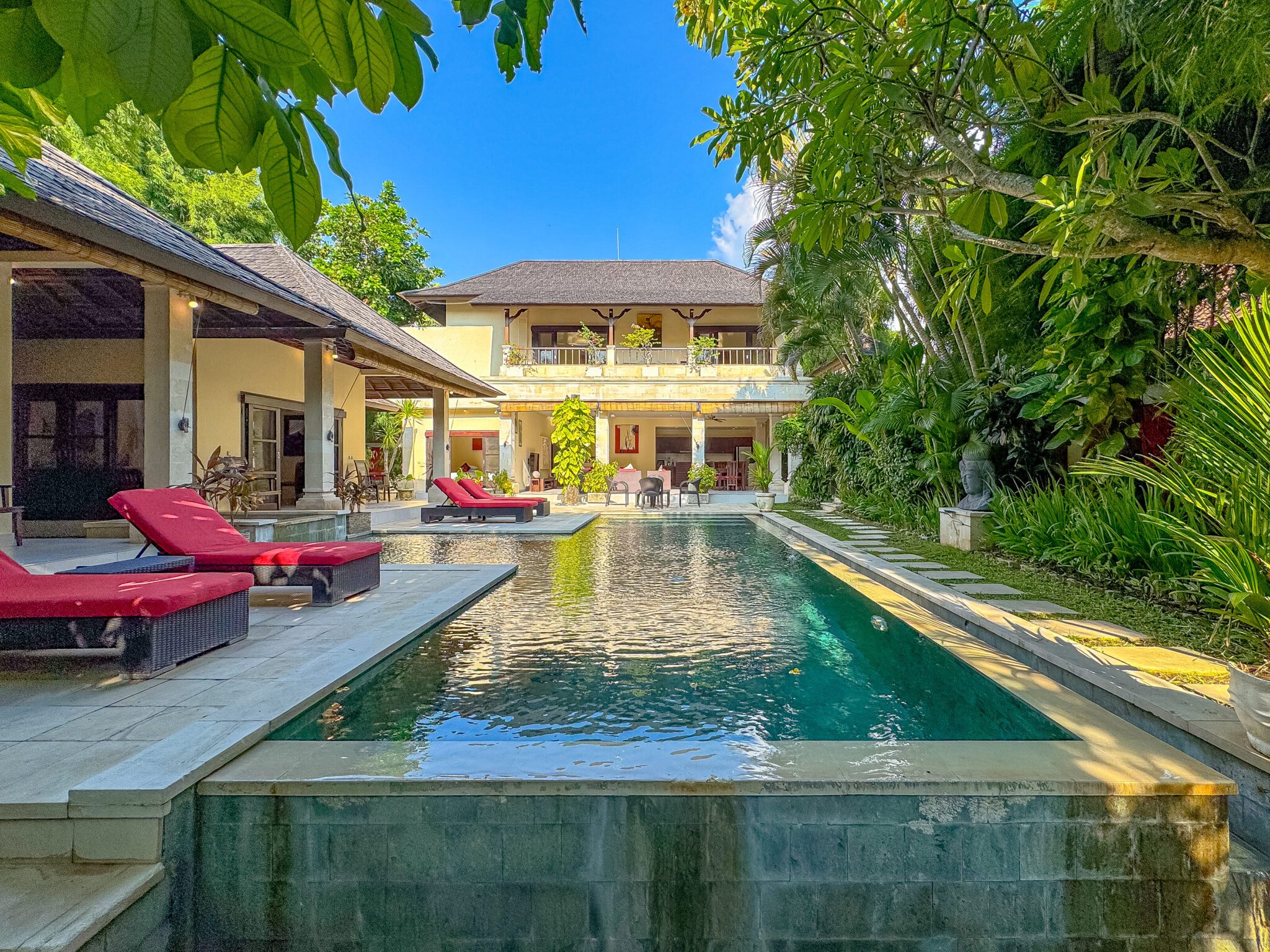 Tropical oasis landscape and spacious poolside relaxation terrace at Villa Tresna Seminyak by Villa Bugis, ideal for family vacations in a villa Seminyak.