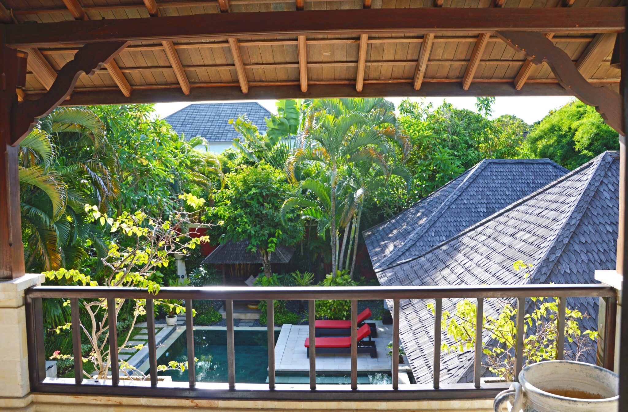 Scenic poolside and garden view from the second terrace balcony of bedroom 5 at Villa Tresna Seminyak by Villa Bugis Seminyak villas.