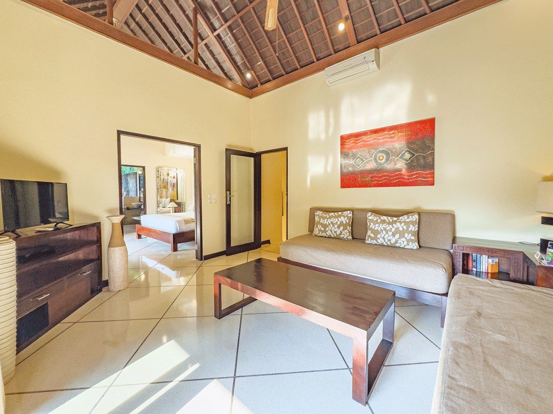 Upstairs TV room with sofas and timber ceiling, convertible to a fifth bedroom, at Villa Tresna Seminyak