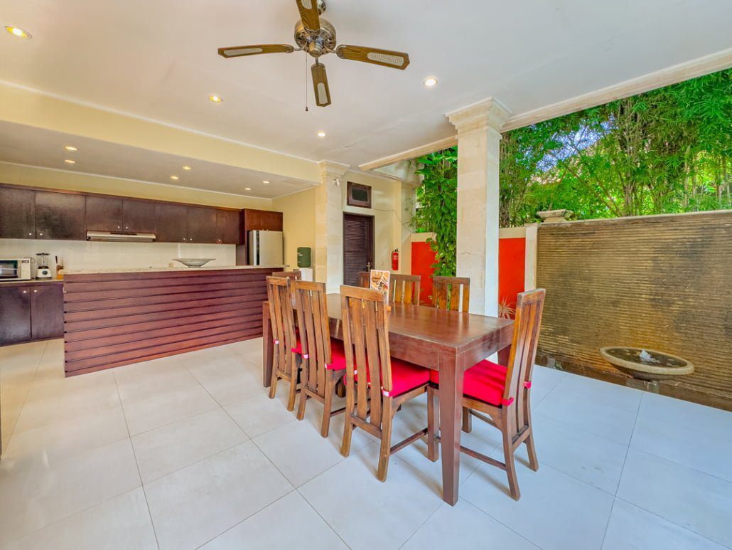 Tropical indoor-outdoor dining space beside the open kitchen at Villa Tresna Seminyak by Villa Bugis Seminyak villas.