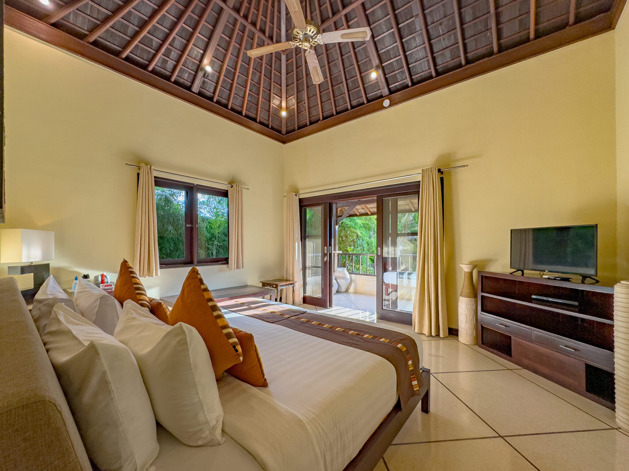 Bedroom 5 opening onto its private balcony, showing the high ceilings and premium bedding at Villa Tresna Seminyak by Villa Bugis Seminyak villas.
