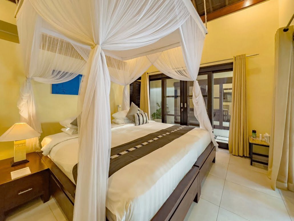 Cozy guest room setup in bedroom 4 at Villa Tresna Seminyak by Villa Bugis Seminyak villas, equipped with air conditioning and tropical accents.