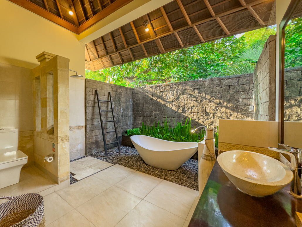 Tropical semi-outdoor ensuite bathroom attached to bedroom 1 at Villa Tresna Seminyak by Villa Bugis, offering a unique villa Seminyak experience.