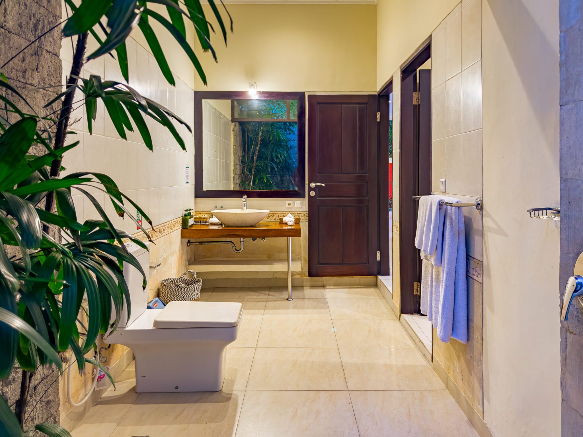 Pristine vanity setup and clean shower space lit at night inside the bathroom of bedroom 2 at Villa Tresna Seminyak by Villa Bugis villa Seminyak.