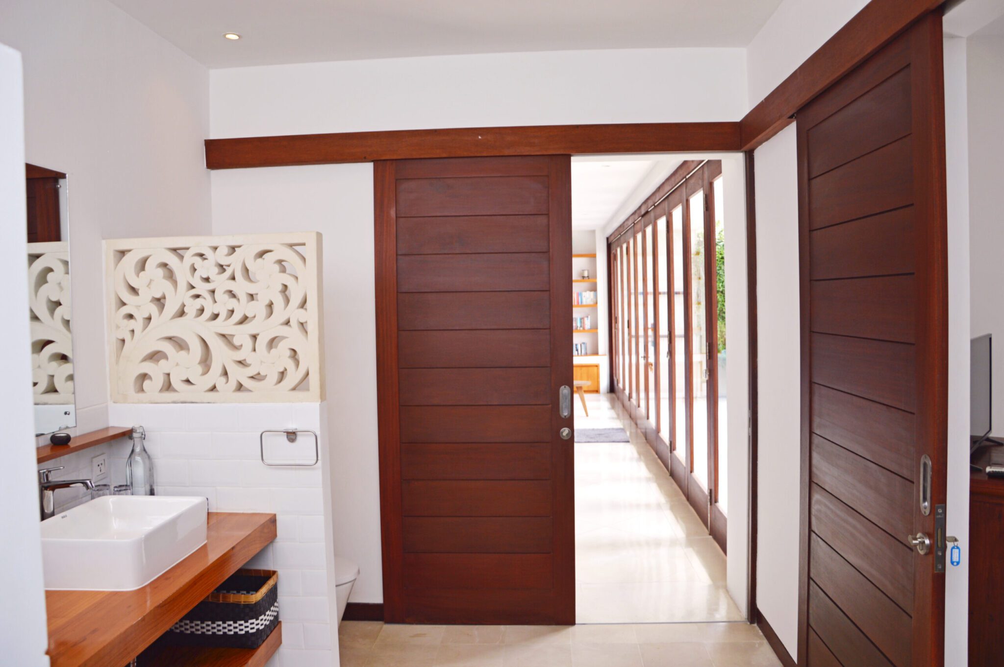 Natural stone elements and modern fittings in the master ensuite bathroom at Villa Umah Kupu-Kupu 2 Seminyak by Villa Bugis villa Seminyak.