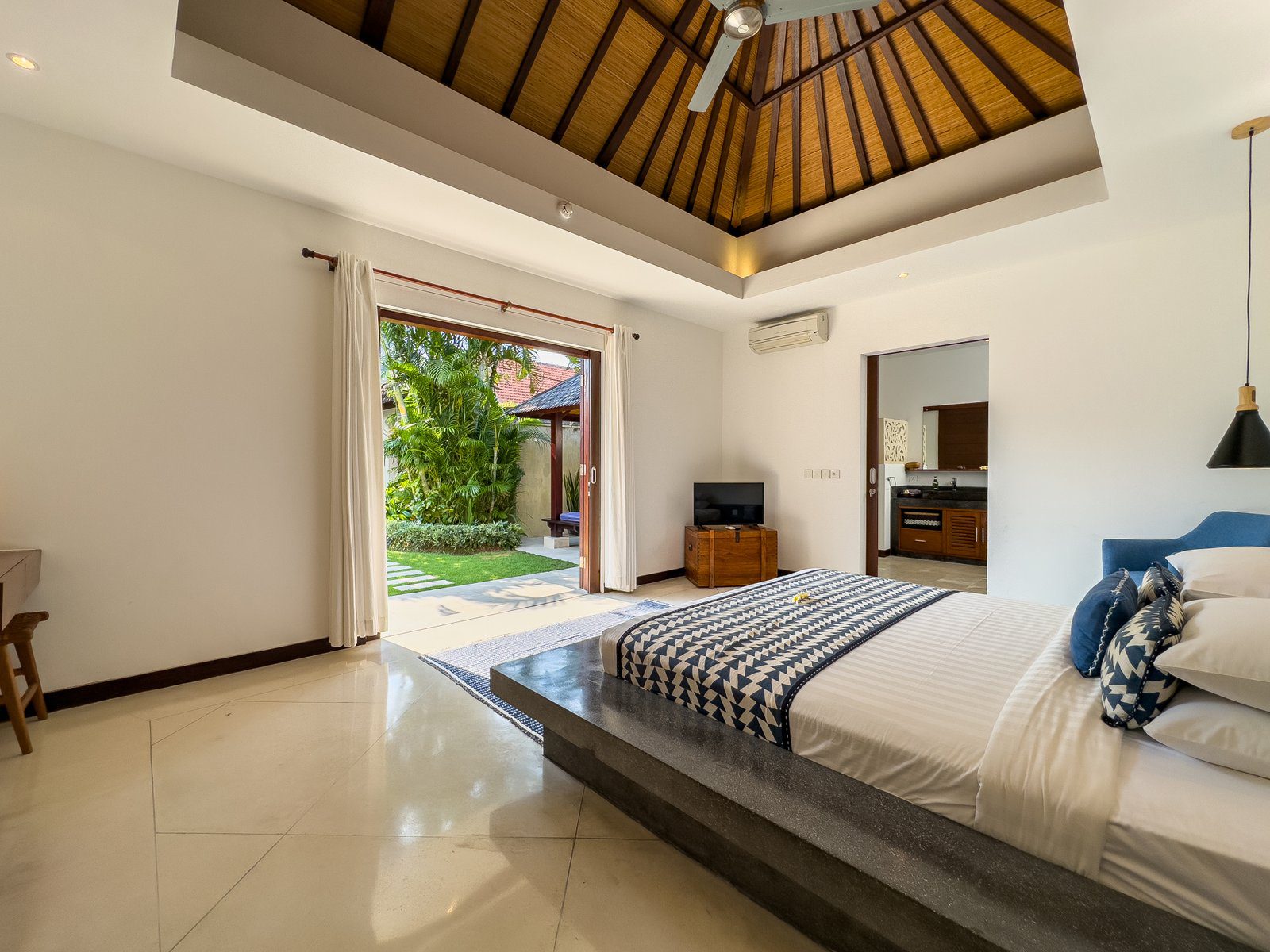 Master bedroom suite featuring a luxurious king-size bed with pool views at Villa Umah Kupu-Kupu 2 Seminyak by Villa Bugis, a top-rated villa Seminyak.