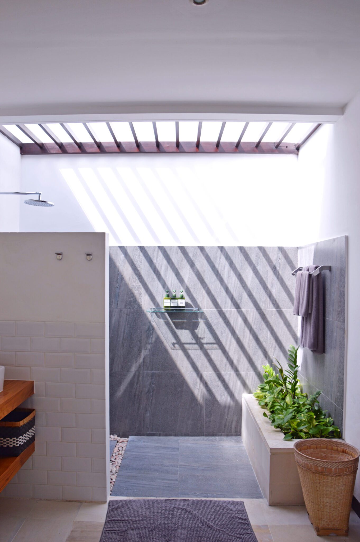 Clean modern vanity, stone basin, and refreshing shower area in the master bathroom at Villa Umah Kupu-Kupu 2 Seminyak by Villa Bugis Seminyak villas.