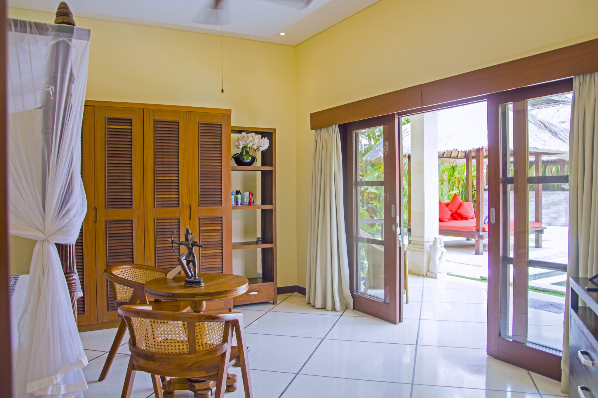 Spacious interior layout of bedroom 1 at Villa Vara Seminyak by Villa Bugis Seminyak villas, complete with air conditioning and elegant wooden furnishings.