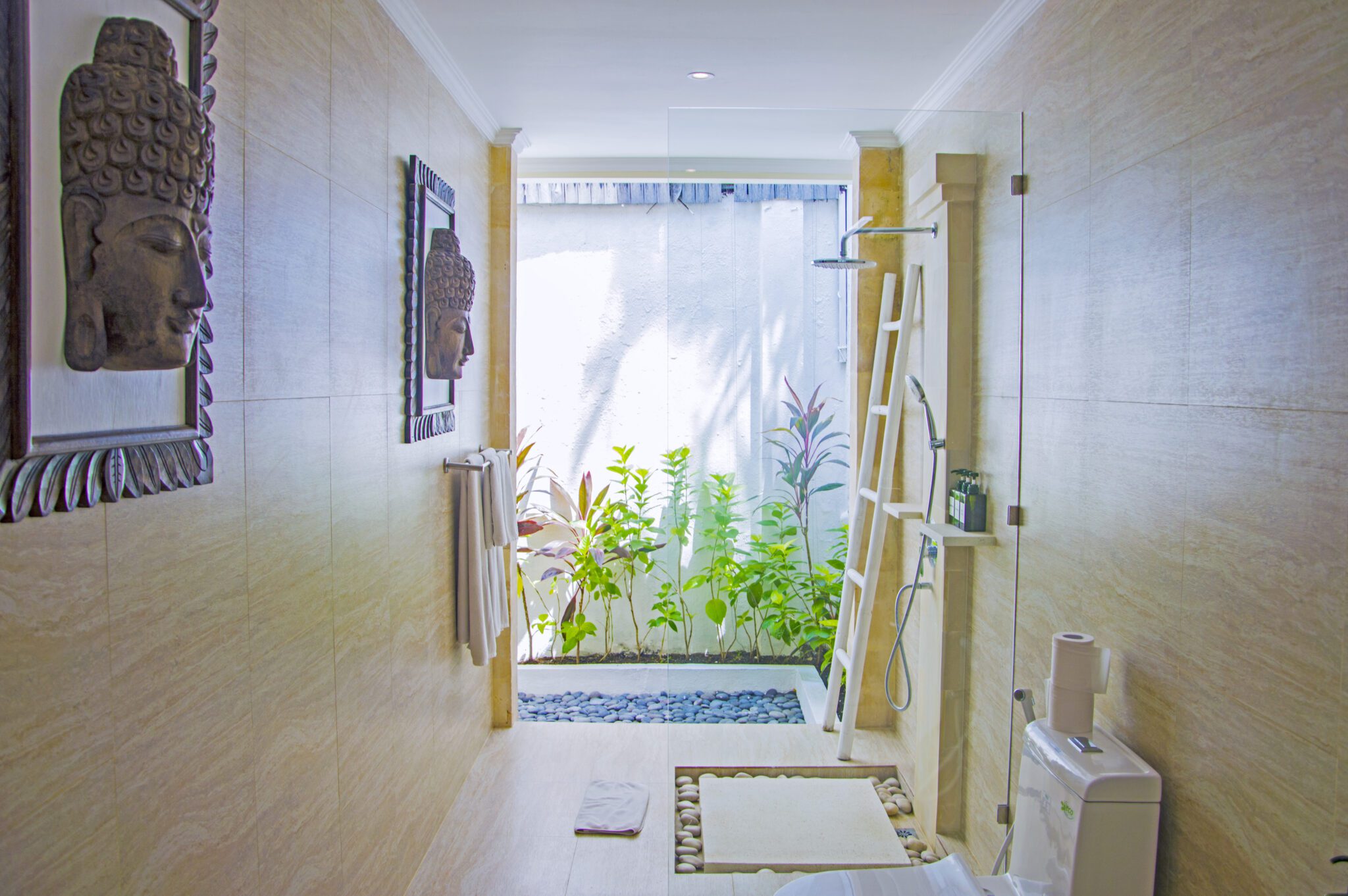 Bright open-air ensuite bathroom with natural stone textures attached to twin bedroom 3 at Villa Vara Seminyak by Villa Bugis Seminyak villas.