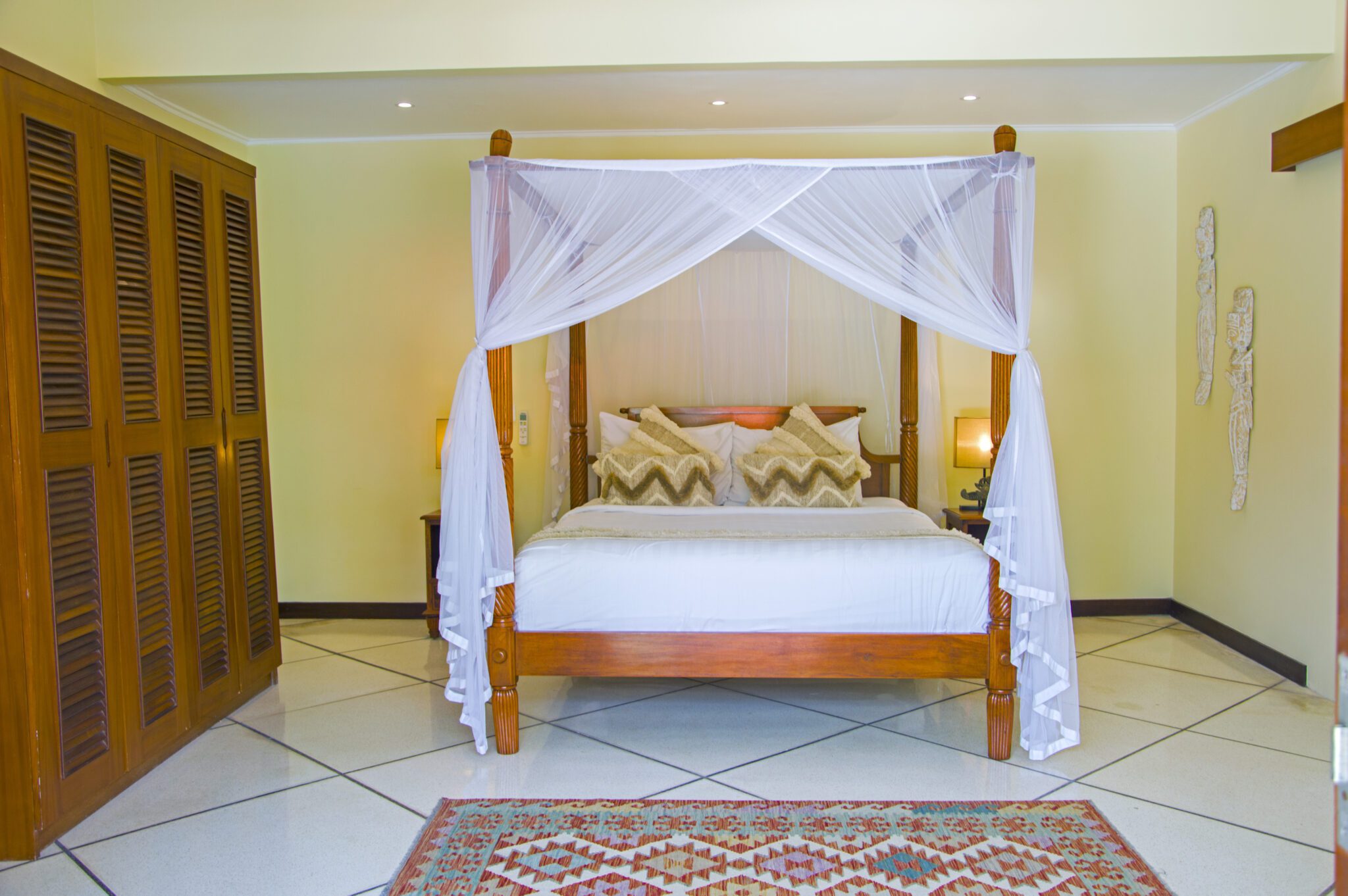 Cozy second bedroom with comfortable king bedding and warm lighting at Villa Vara Seminyak by Villa Bugis, ideal for Seminyak villas guests.