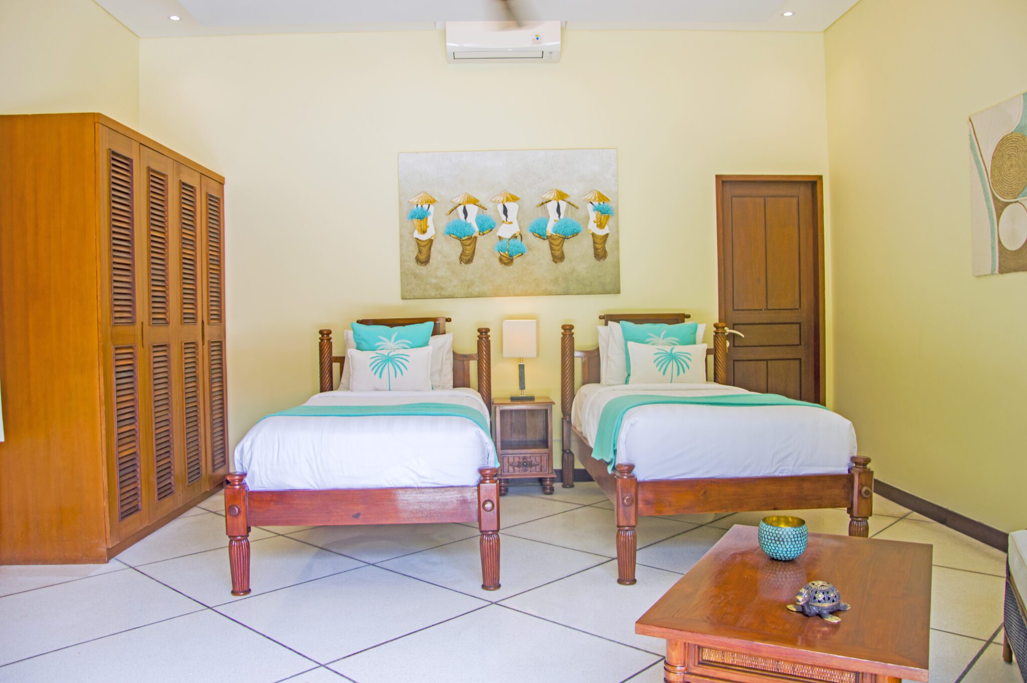 Airy twin bedroom interior setup at Villa Vara Seminyak by Villa Bugis Seminyak villas, equipped with air conditioning and comfortable double single beds.